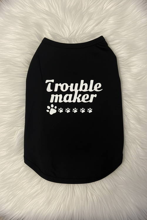 Black pet shirt with 'Trouble maker' text on a fluffy white surface