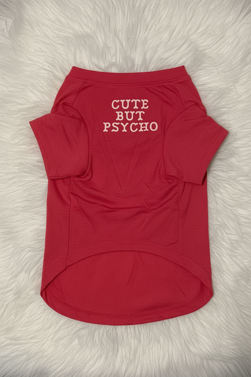 Red pet shirt with 'Cute But Psycho' text on a fluffy white surface
