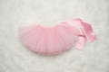 Pink tutu skirt with a ribbon on a white fluffy surface